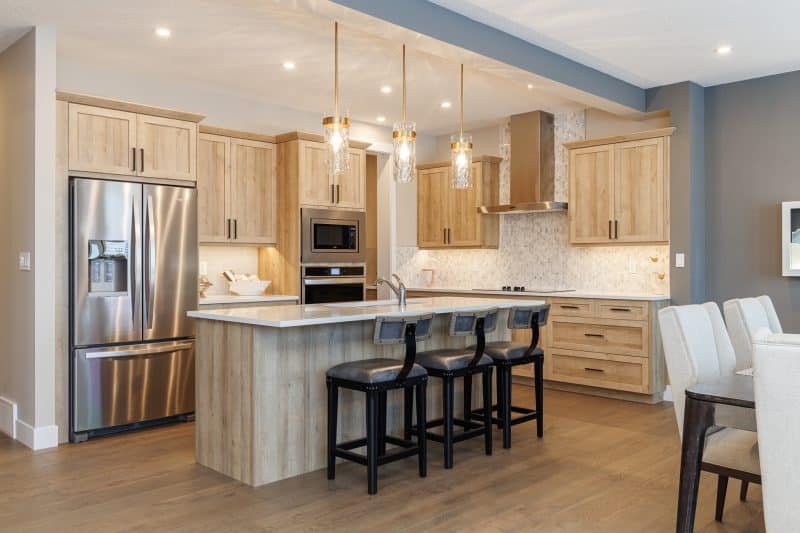 Open concept kitchen with wood cupboards.
Cuisine à aire ouverte pourvue d’armoires en bois.