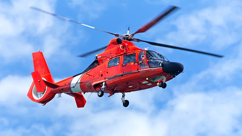 A red medical helicopter in the sky.
Un hélicoptère médical rouge dans le ciel.