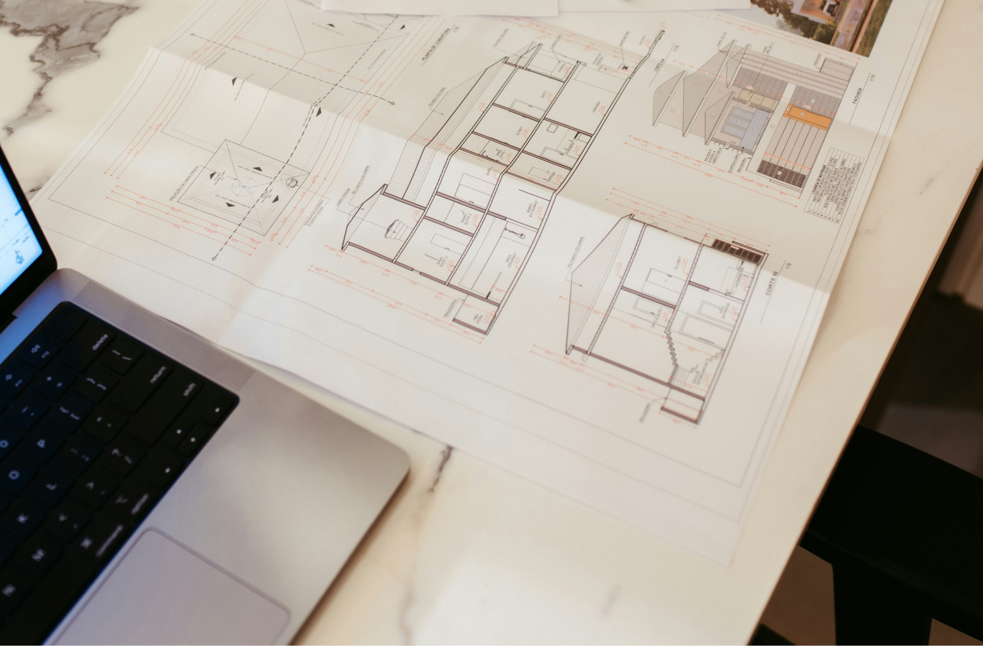 Researching home floor plans with a laptop and printed documents