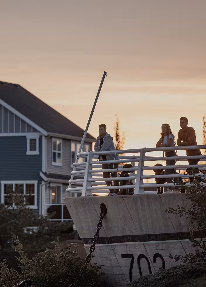 People standing on a boat-shaped lookout at the Nonsuch Plaza, with homes and landscaping nearby.