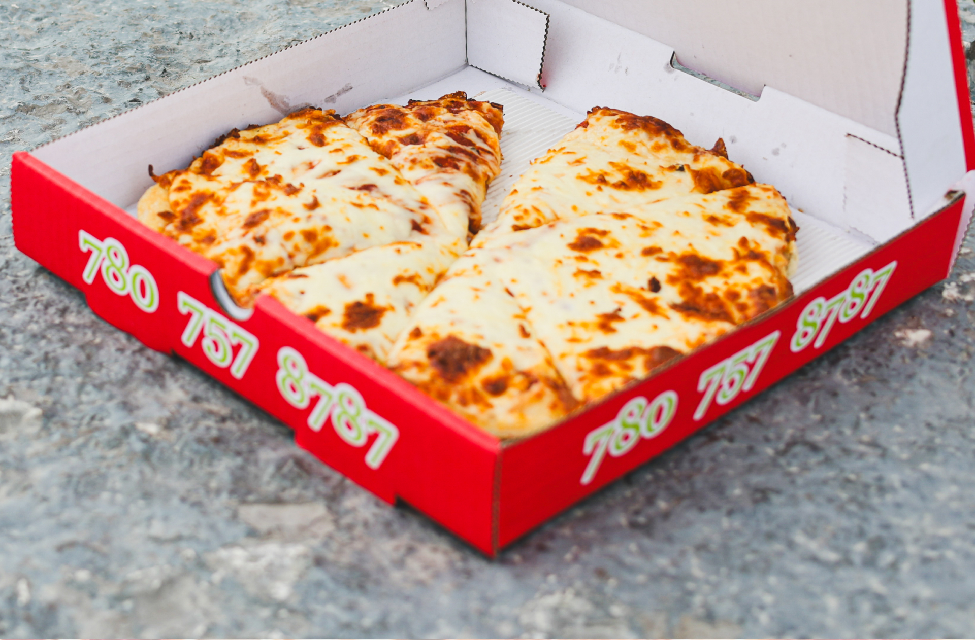A box of cheesy pizza