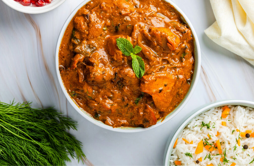 A bowl of Indian curry and seasoned rice